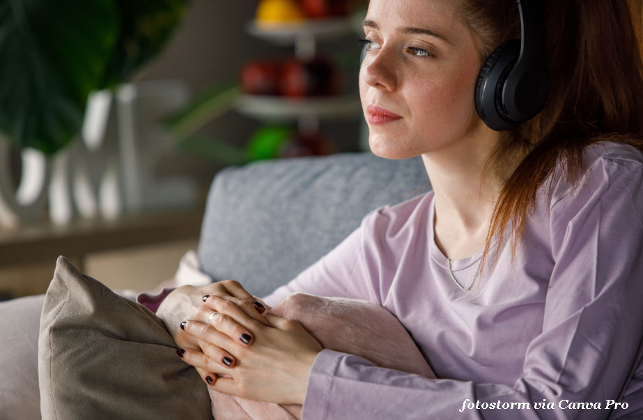young woman listening to audiobook with earphones